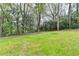 A sloping green backyard is enhanced by mature trees and lush landscaping at 1450 Cedarhurst Dr, Dunwoody, GA 30338