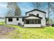 Spacious backyard with the home's exterior, landscaping and screened in porch at 1450 Cedarhurst Dr, Dunwoody, GA 30338