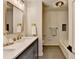 Modern bathroom with double sinks, marble countertop, gold fixtures, and bathtub at 1450 Cedarhurst Dr, Dunwoody, GA 30338