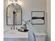 Modern bathroom features a white vanity, elegant mirror, and contemporary lighting at 1450 Cedarhurst Dr, Dunwoody, GA 30338