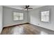 Bedroom featuring hardwood floors, ceiling fan, and natural light from two windows at 1450 Cedarhurst Dr, Dunwoody, GA 30338
