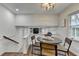 Bright dining area with modern light fixture, wood floors, and stairway to living area at 1450 Cedarhurst Dr, Dunwoody, GA 30338