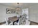 Bright dining area with dark wood table, upholstered chairs, decorative art, and hardwood floors at 1450 Cedarhurst Dr, Dunwoody, GA 30338