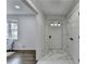 Bright foyer showcases elegant marble flooring, complementing the nearby hardwood-floored living area and front door at 1450 Cedarhurst Dr, Dunwoody, GA 30338