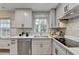 Cozy kitchen featuring white cabinets, stone tile backsplash, and stainless steel dishwasher at 1450 Cedarhurst Dr, Dunwoody, GA 30338