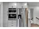 Stainless steel refrigerator and double ovens are surrounded by white cabinets in this home's kitchen at 1450 Cedarhurst Dr, Dunwoody, GA 30338