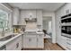 Modern kitchen with stainless steel appliances, white cabinets, and view into dining area at 1450 Cedarhurst Dr, Dunwoody, GA 30338