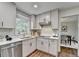 Well-lit kitchen with white cabinets, stainless steel appliances, and tile backsplash at 1450 Cedarhurst Dr, Dunwoody, GA 30338