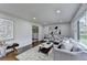 Bright living room with modern decor, plush rug, and large windows offering great natural light and an inviting atmosphere at 1450 Cedarhurst Dr, Dunwoody, GA 30338