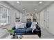 Open living room with a large window, view to the kitchen and cozy blue couch at 1450 Cedarhurst Dr, Dunwoody, GA 30338
