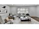 Sunlit living room boasts stylish seating, large window, and plush rug, perfect for relaxed gatherings at 1450 Cedarhurst Dr, Dunwoody, GA 30338