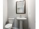Stylish powder room featuring a pedestal sink, decorative mirror and modern fixtures at 4589 Hawthorn Rose Ln, Buford, GA 30518