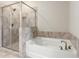 Bathroom featuring separate shower and tub with tile surround at 4589 Hawthorn Rose Ln, Buford, GA 30518