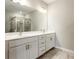 Bathroom with double sinks, quartz countertops, framed mirror and modern lighting at 4589 Hawthorn Rose Ln, Buford, GA 30518
