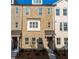 Charming townhome featuring a brick facade, covered entry, and multiple windows at 4589 Hawthorn Rose Ln, Buford, GA 30518