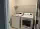 Convenient laundry room with a washer, dryer, and wire shelving at 4589 Hawthorn Rose Ln, Buford, GA 30518