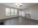 Bright and airy living room featuring wood-look floors, large windows, and staircase access at 4589 Hawthorn Rose Ln, Buford, GA 30518