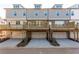 Rear view of townhomes showcasing garage entrances and outdoor deck areas at 4589 Hawthorn Rose Ln, Buford, GA 30518