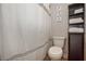 The bathroom showcases a toilet, a white shower curtain, and a dark wooden cabinet at 5111 Olive Branch Cir, Powder Springs, GA 30127
