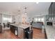 Open concept kitchen with island seating, dark cabinets, and stainless steel appliances that opens to living room at 5111 Olive Branch Cir, Powder Springs, GA 30127