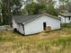 Exterior side view of a newly renovated home with a small back porch and an AC unit at 517 Whitley Dr, Forest Park, GA 30297