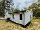 Side view of a newly renovated home with new siding, black gutters and a small porch at 517 Whitley Dr, Forest Park, GA 30297