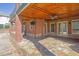 A brick-columned patio with stone flooring offers seating and access to the backyard at 6925 Lighthouse Point, Cumming, GA 30041
