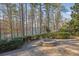 Lakefront backyard featuring a stone fire pit and lush landscaping for outdoor enjoyment at 6925 Lighthouse Point, Cumming, GA 30041