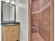 Bathroom featuring a walk-in tiled shower and decorative mirror over a vanity at 6925 Lighthouse Point, Cumming, GA 30041