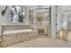 Well lit bathroom featuring a soaking tub and a large glass enclosed walk in shower with tile surround at 6925 Lighthouse Point, Cumming, GA 30041