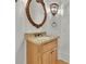 Powder room features wood vanity, decorative mirror, and elegant sconce lighting at 6925 Lighthouse Point, Cumming, GA 30041