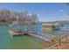 Lake view of covered boat dock featuring a boat lift and seating area at 6925 Lighthouse Point, Cumming, GA 30041