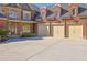 Home exterior featuring a three-car garage, brick facade, and a paved driveway, offering convenience and curb appeal at 6925 Lighthouse Point, Cumming, GA 30041