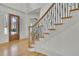 Foyer showcasing a staircase with wood and iron detailing, leading to the upper levels of the home at 6925 Lighthouse Point, Cumming, GA 30041