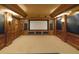 A spacious home theater with wood paneling and a large screen for immersive entertainment with custom built in storage and lighting at 6925 Lighthouse Point, Cumming, GA 30041