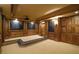 Elegant home theater with tiered seating, wood paneling, and a projector screen, perfect for immersive entertainment experiences at 6925 Lighthouse Point, Cumming, GA 30041