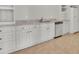 A charming kitchenette features white cabinets, stone counters and stainless dishwasher at 6925 Lighthouse Point, Cumming, GA 30041