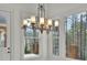 Bright sunroom featuring a decorative chandelier, large windows, and views of the wooded backyard at 6925 Lighthouse Point, Cumming, GA 30041