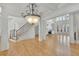Open-concept living room featuring hardwood floors, a fireplace and staircase with detailed trim at 6925 Lighthouse Point, Cumming, GA 30041