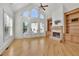Open living room featuring hardwood floors, a stone fireplace, built-in shelves, and clerestory windows at 6925 Lighthouse Point, Cumming, GA 30041