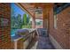 This outdoor kitchen features a stone floor, brick columns and a BBQ grill under wood ceiling at 6925 Lighthouse Point, Cumming, GA 30041