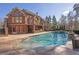 Stunning brick home featuring a spacious pool, outdoor kitchen, and balcony, ideal for elegant outdoor living and entertaining at 6925 Lighthouse Point, Cumming, GA 30041