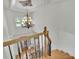 Staircase featuring decorative chandelier, wooden stairs and railing, and iron spindles at 6925 Lighthouse Point, Cumming, GA 30041