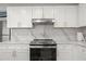 Modern kitchen showcasing marble backsplash, stainless steel hood, and sleek white countertops at 1500 Tara Pl # 709, Hampton, GA 30228
