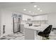Modern kitchen with white cabinets, a stainless steel refrigerator, marble countertops, and stylish bar stools at 1500 Tara Pl # 709, Hampton, GA 30228