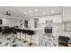 Bright, modern kitchen with white cabinets, marble countertops, stylish bar seating, and stainless steel appliances at 1500 Tara Pl # 709, Hampton, GA 30228