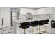 Modern kitchen with white cabinets, a stainless steel refrigerator, marble countertops, and stylish bar stools at 1500 Tara Pl # 709, Hampton, GA 30228