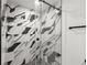 Glass shower featuring black and white patterned tile, black hardware, and a rainfall shower head at 1500 Tara Pl # 709, Hampton, GA 30228