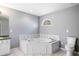 Bright bathroom with a corner tub, white tile floor, and a toilet at 300 Smith Ave, Bowdon, GA 30108