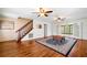 Bright living room featuring hardwood floors, ceiling fans, and access to other rooms at 300 Smith Ave, Bowdon, GA 30108
